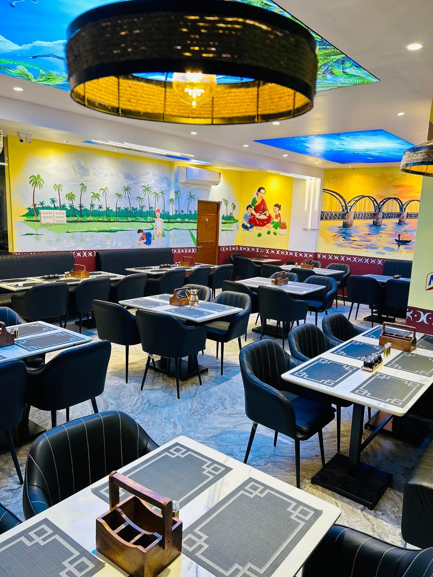 Godavari VVM restaurant interior with tables and Godavari wall murals
